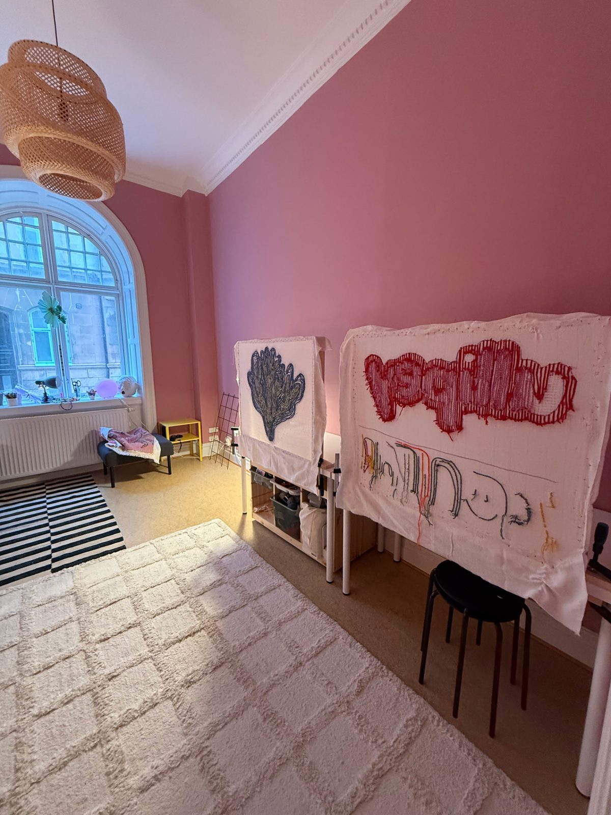 Tuftningsramar med påbörjade verk i ullipeys studio med rosa väggar